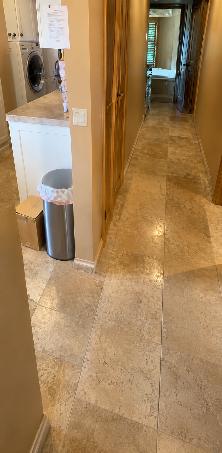 AI-upscaled photoreal render generated from the voxel reconstruction of the hallway, showing laundry area, trash can, tiled floor, and hallway.